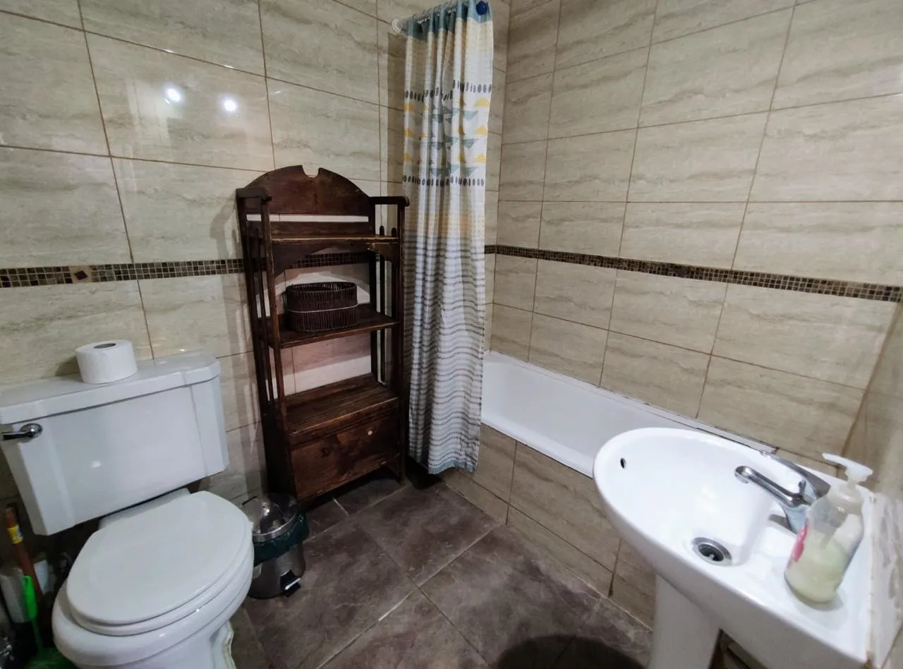Baño privado con mueble de madera y tina