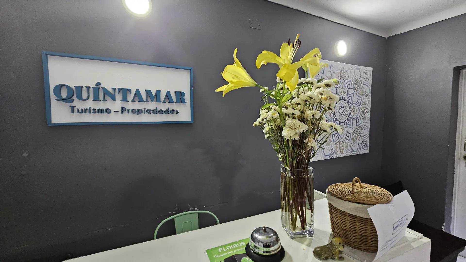Recepción principal con flores y el logo de Turismo Quintamar Propiedades
